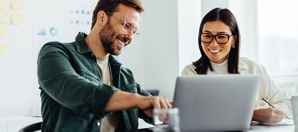 Frau und Mann bearbeiten E-Learning Kurs am Notebook.